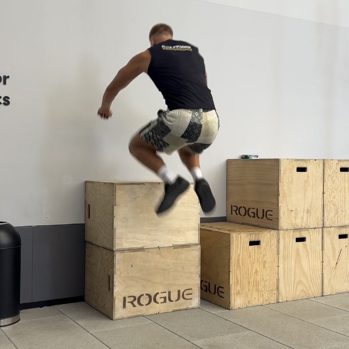 Swimmer performing a box jump in the gym